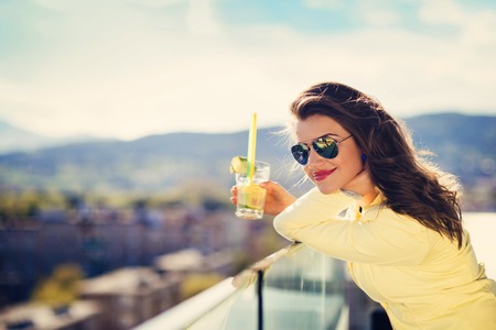 40551953 - attractive young woman with a drink on a terrace of a bar