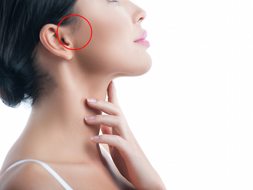 I like making skincare treatment. Attractive young woman is applying moisturizer on her neck. Isolated and copy space in right side