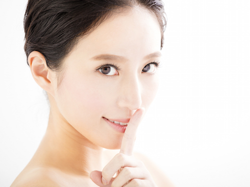 closeup young woman face with quiet gesture