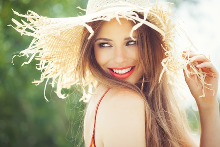 39840318 - young woman in straw hat smiling in summer outdoors.