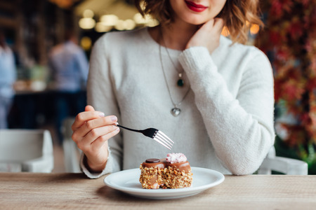 52823707 - closeup of woman eating chocolate cake in a cafe