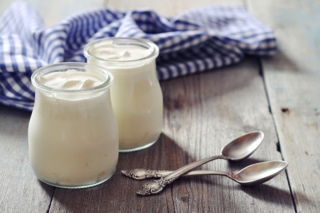 23472962 - greek yogurt in a glass jars with spoons on wooden background