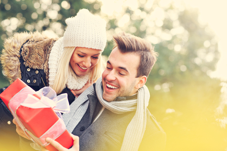 47846763 - a picture of a young couple with a present in the park